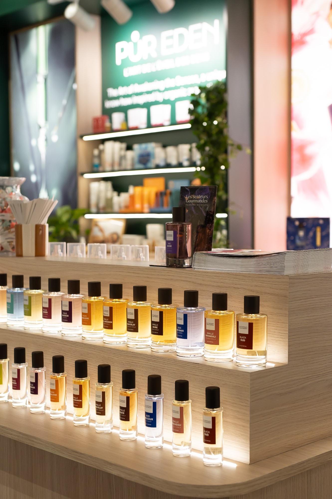 Comptoir en gradins éclairé par LED présentant la collection de parfums Les Senteurs Gourmandes